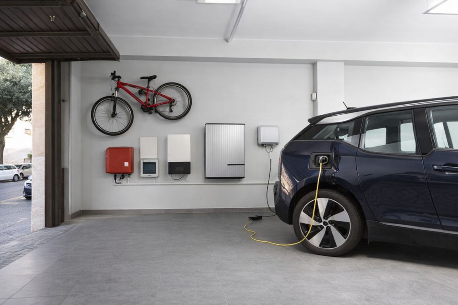 Elbil laddas i ett modernt garage med laddbox och väggmonterad utrustning.